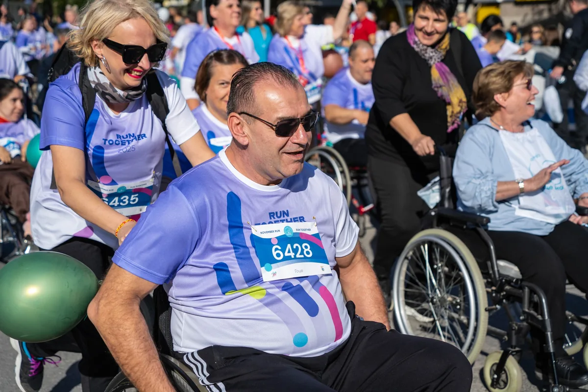 Учесник со количка и асистент на Run Together 2025